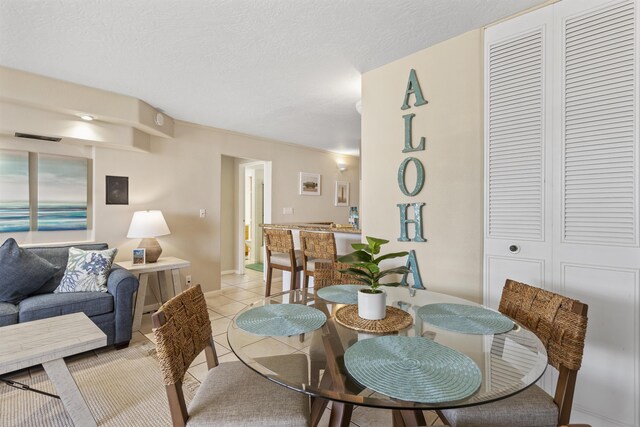 dining space featuring a textured ceiling and light tile patterned floors