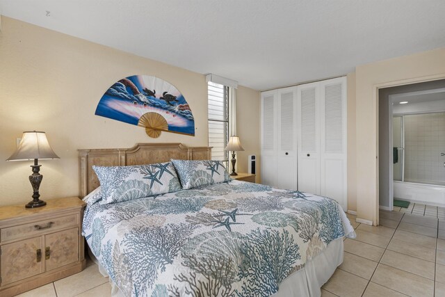 tiled bedroom featuring a closet and ensuite bathroom