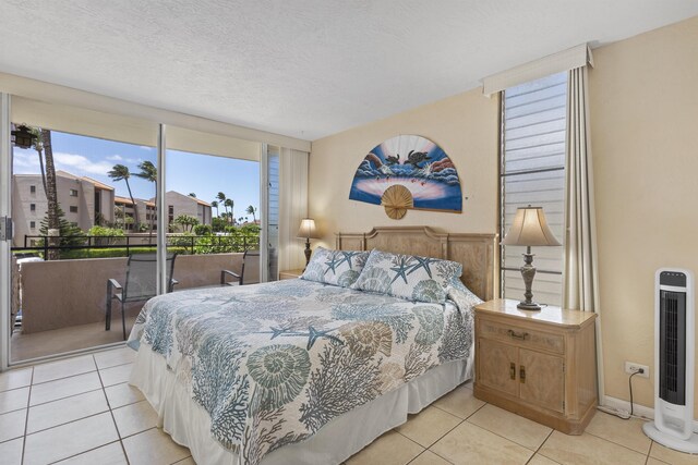 tiled bedroom featuring access to outside and a textured ceiling