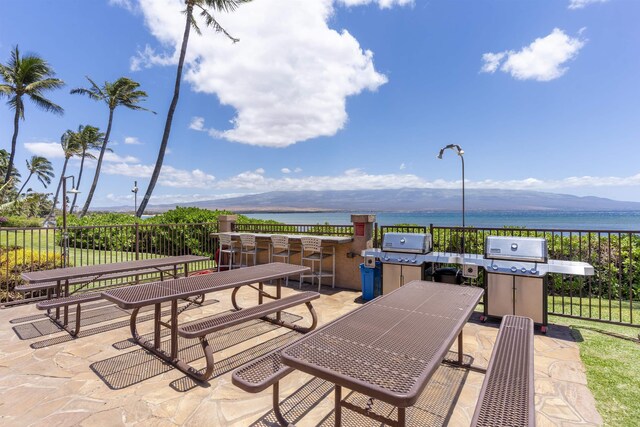 view of patio / terrace with a water and mountain view