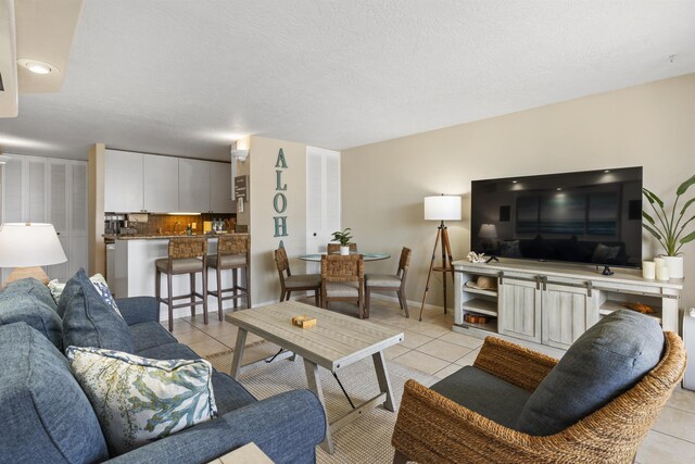 tiled living room featuring a textured ceiling