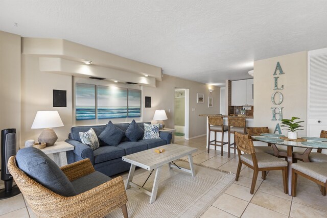 living room featuring light tile patterned floors and a textured ceiling