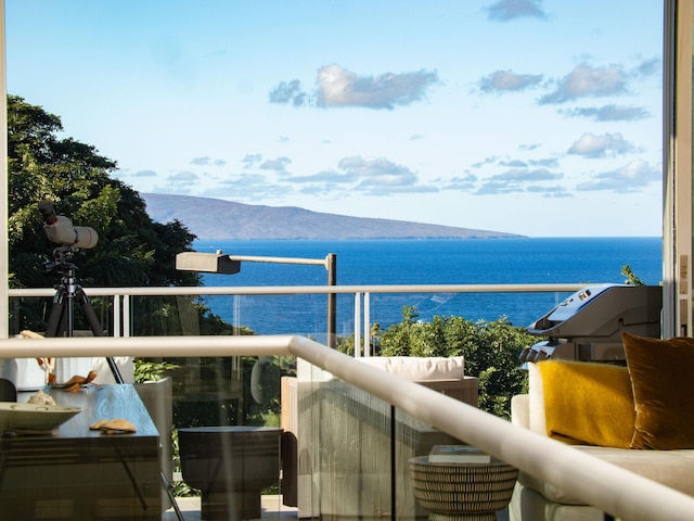 balcony featuring a water and mountain view