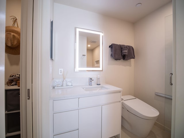 bathroom with vanity, a shower with shower door, and toilet