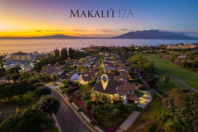 aerial view at dusk featuring a water and mountain view