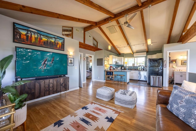 living room with ceiling fan, lofted ceiling with beams, and wood-type flooring