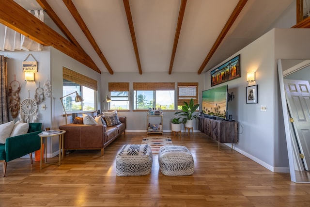 living room featuring lofted ceiling with beams and light hardwood / wood-style flooring