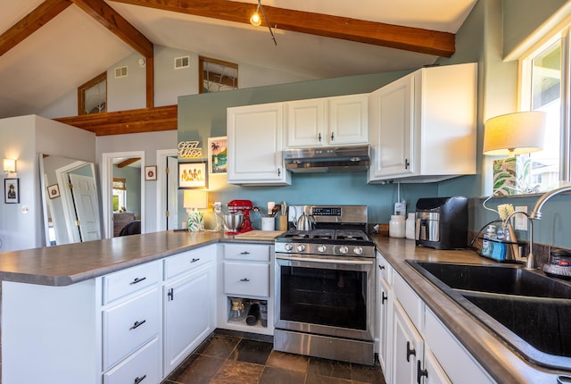 kitchen featuring kitchen peninsula, beamed ceiling, stainless steel range, and white cabinets