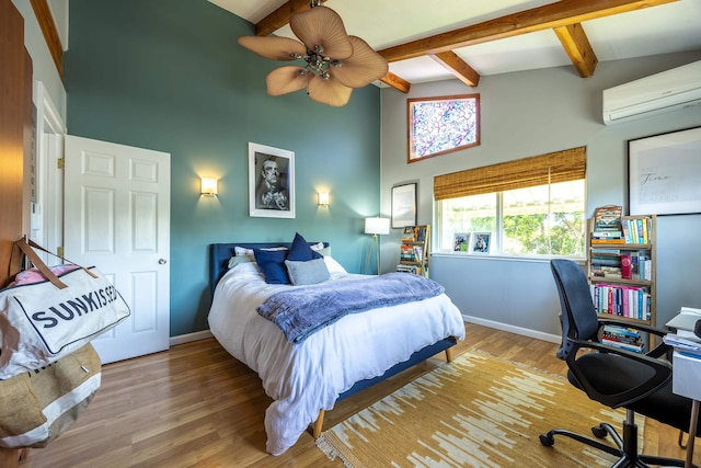 bedroom with lofted ceiling with beams, a wall unit AC, light hardwood / wood-style floors, and ceiling fan