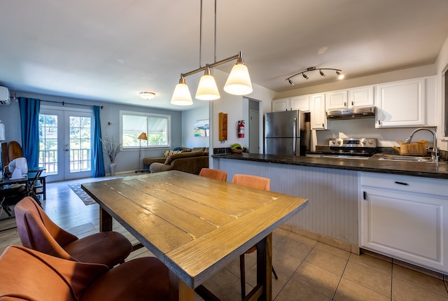 kitchen with sink, white cabinetry, decorative light fixtures, and stainless steel appliances