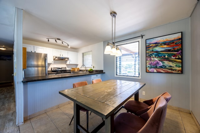 tiled dining space featuring sink and wooden walls