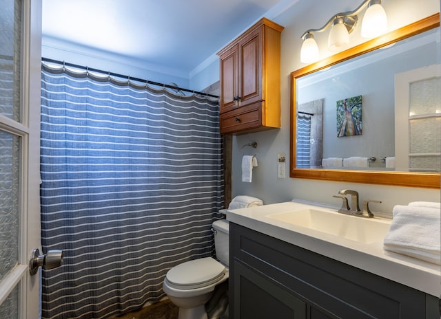 bathroom with vanity, crown molding, toilet, and walk in shower