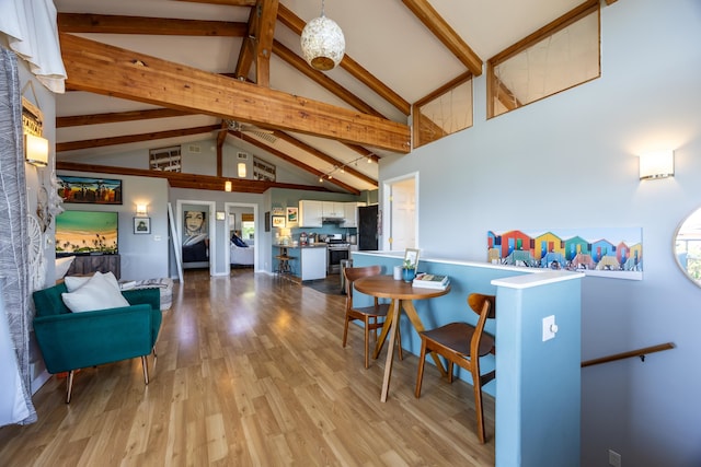 dining space featuring beamed ceiling, high vaulted ceiling, and light wood-type flooring