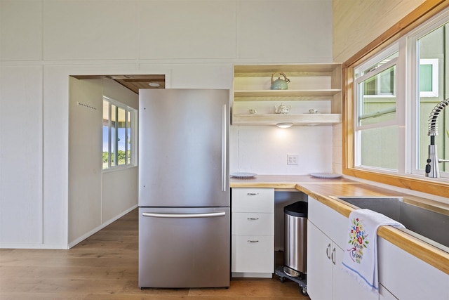 34701 Piilani Hwy, Hana, HI 96713 - kitchen featuring freestanding refrigerator, a sink, white cabinets, light wood finished floors, and open shelves