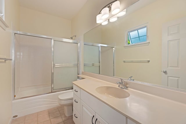 full bathroom featuring vanity, shower / bath combination with glass door, toilet, and tile patterned flooring