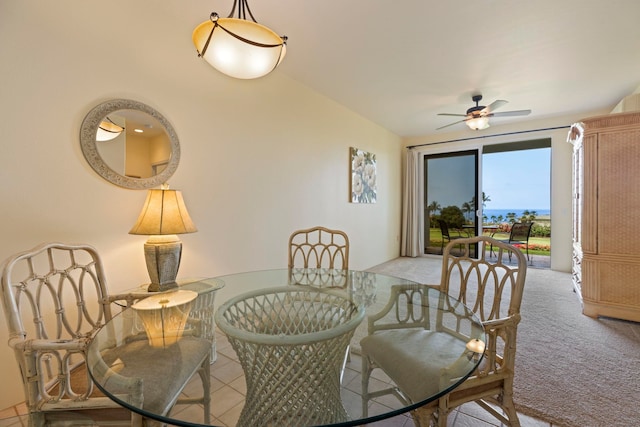 carpeted dining room with ceiling fan