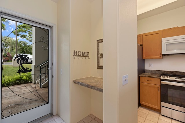 kitchen with stainless steel stove and light tile patterned floors