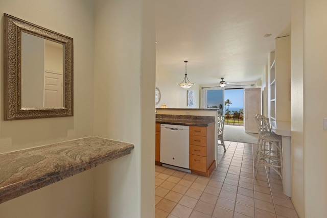 kitchen featuring kitchen peninsula, pendant lighting, ceiling fan, white dishwasher, and light tile patterned floors