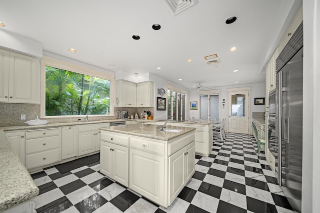 212 Crestview Rd, Lahaina, HI 96761 - kitchen with a center island with sink, decorative backsplash, recessed lighting, ceiling fan, and white cabinets