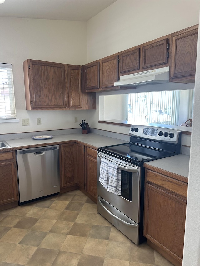 kitchen with light countertops, appliances with stainless steel finishes, and under cabinet range hood