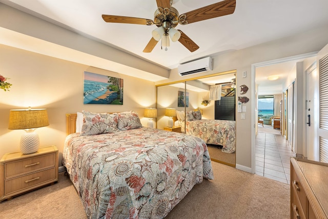 carpeted bedroom with ceiling fan, a water view, an AC wall unit, and a closet