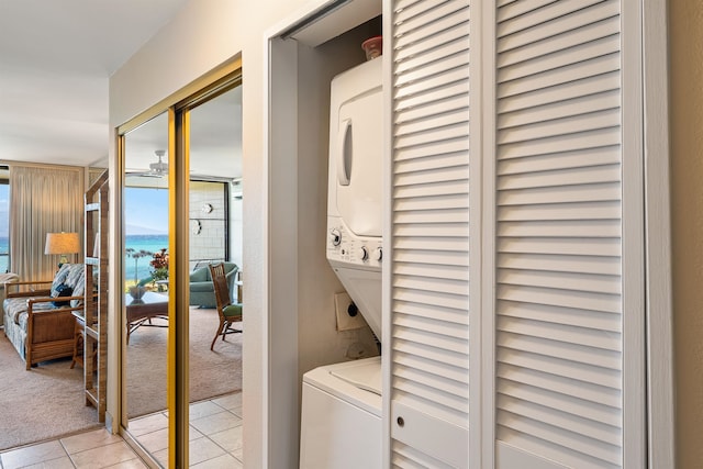 washroom featuring stacked washing maching and dryer and light tile patterned floors