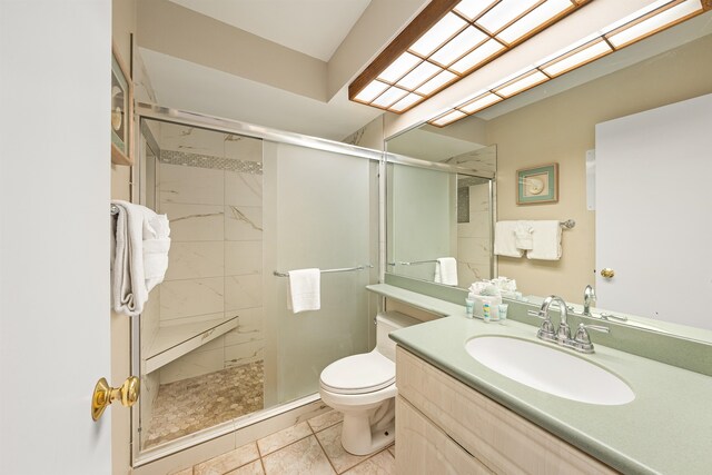 bathroom featuring walk in shower, vanity, toilet, and tile patterned flooring