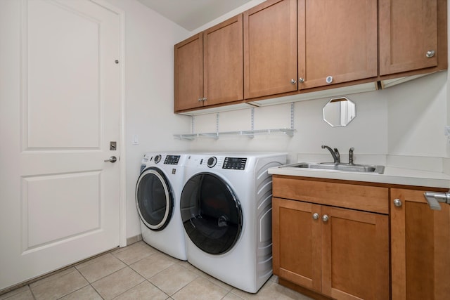 laundry area with cabinets, sink, washing machine and dryer, and light tile patterned floors