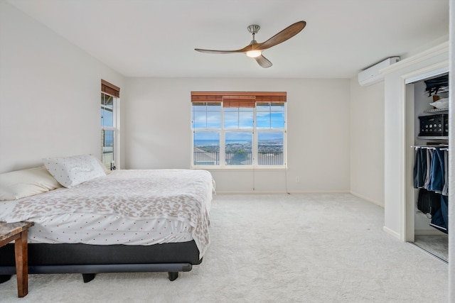 carpeted bedroom featuring a wall unit AC, a closet, and ceiling fan