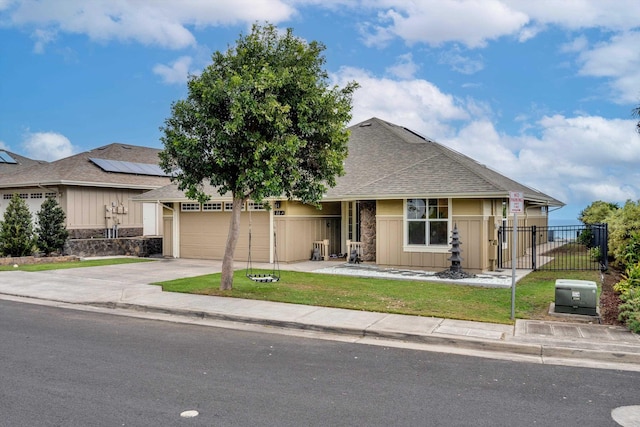 view of front of house featuring a garage, a front lawn, and solar panels