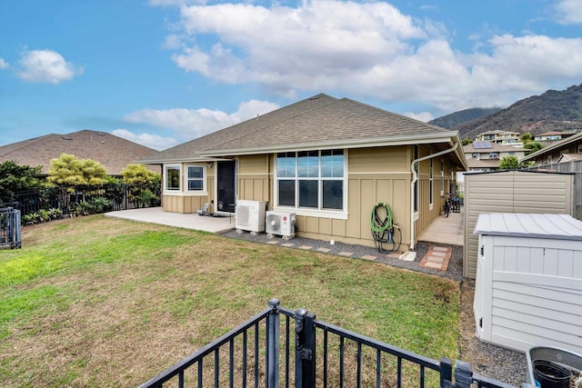 back of property featuring a patio, a mountain view, a lawn, and a storage unit