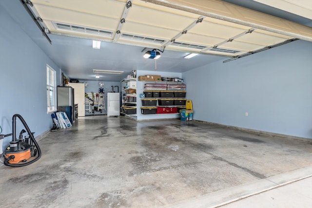 garage featuring a garage door opener and white fridge