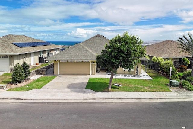 ranch-style house featuring a garage, a front yard, and solar panels