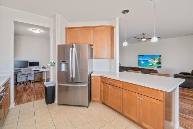 kitchen featuring light tile patterned floors, ceiling fan, hanging light fixtures, stainless steel refrigerator with ice dispenser, and kitchen peninsula