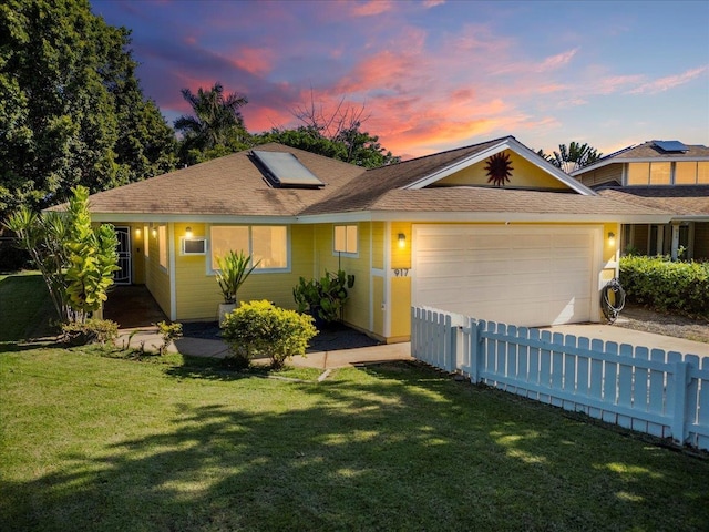 view of front facade with a garage and a yard