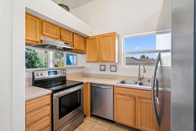 kitchen featuring sink, light tile patterned floors, stainless steel appliances, and extractor fan