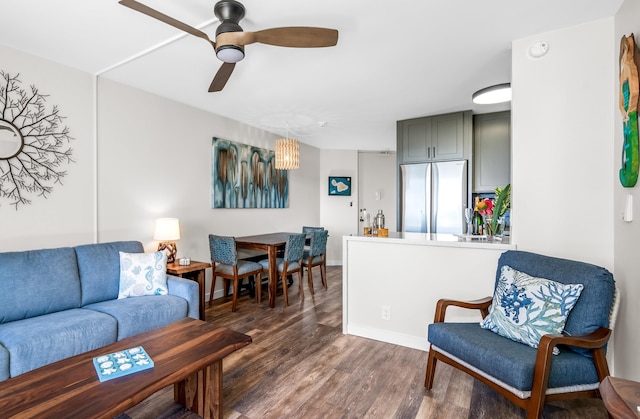 living room with dark hardwood / wood-style flooring and ceiling fan