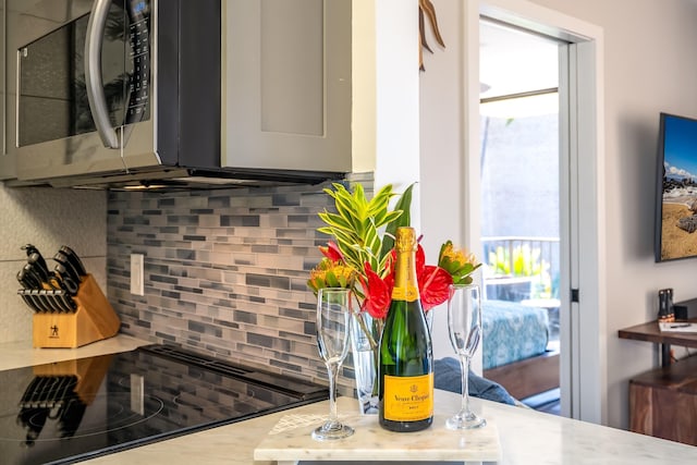 kitchen with black electric cooktop and tasteful backsplash