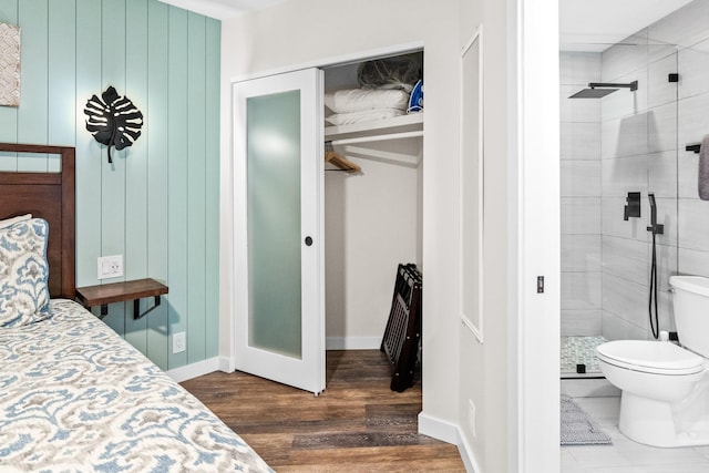 bedroom with ensuite bath, a closet, and dark hardwood / wood-style floors