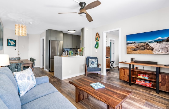 living room with dark hardwood / wood-style floors and ceiling fan with notable chandelier