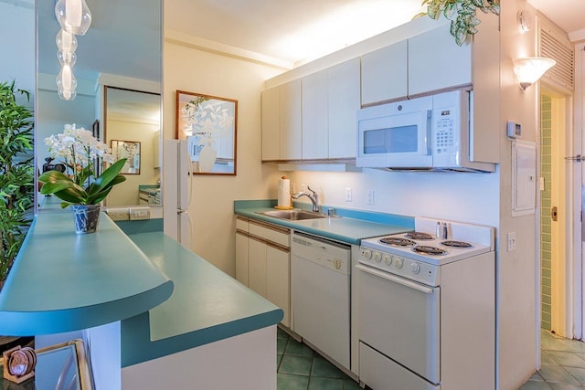 kitchen featuring tile patterned flooring, decorative light fixtures, light countertops, white appliances, and a sink