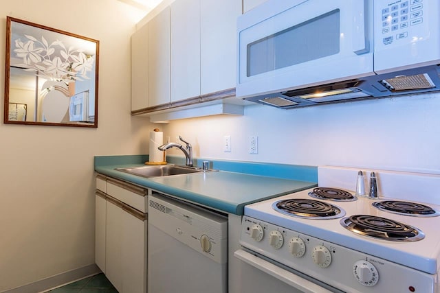 kitchen with a sink, white appliances, white cabinets, light countertops, and baseboards