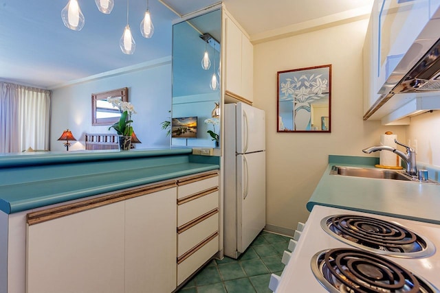 kitchen with white appliances, dark tile patterned flooring, a sink, white cabinets, and decorative light fixtures