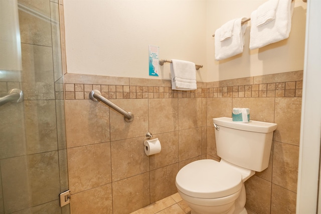 bathroom with tile patterned floors, toilet, and tile walls