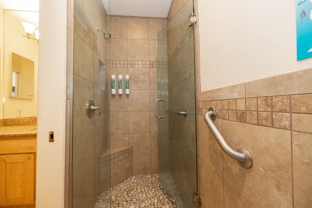 bathroom with tile walls, vanity, and an enclosed shower