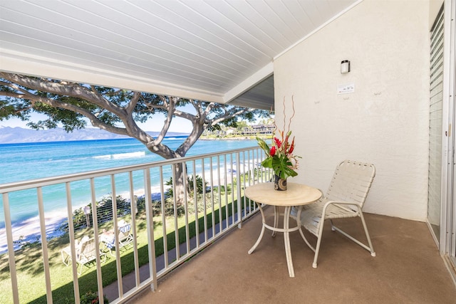 balcony with a water view and a beach view