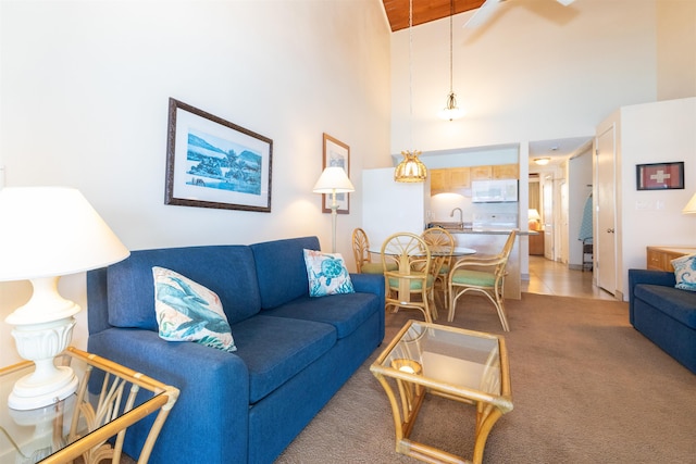 living room featuring light carpet, beam ceiling, high vaulted ceiling, and sink