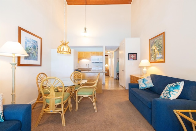 carpeted dining room with sink and a high ceiling