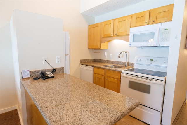 kitchen with sink, white appliances, kitchen peninsula, and light tile patterned floors