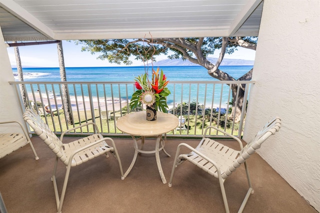 balcony featuring a beach view and a water view